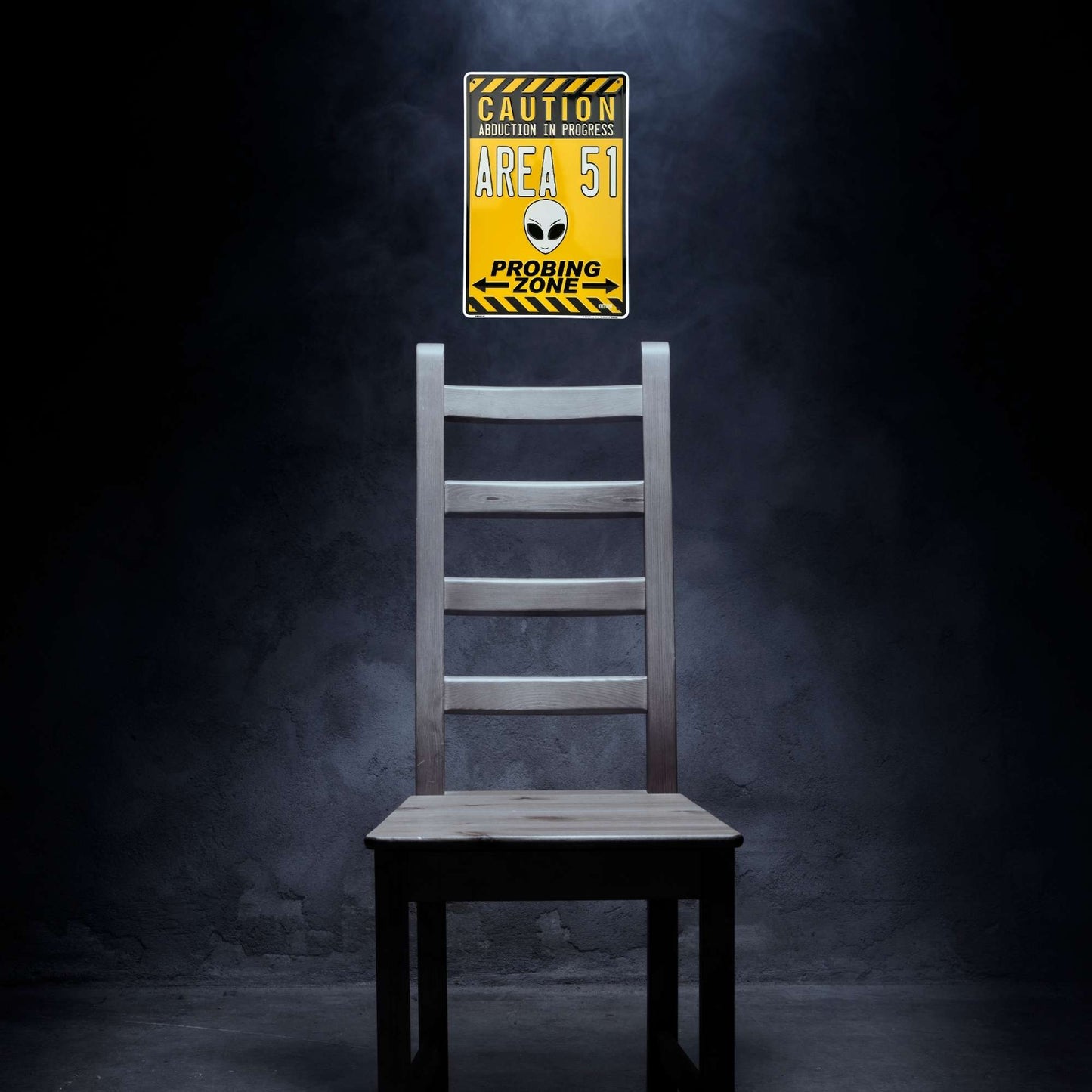 Wooden chair with a 'Caution Area 51' sign on a dark background