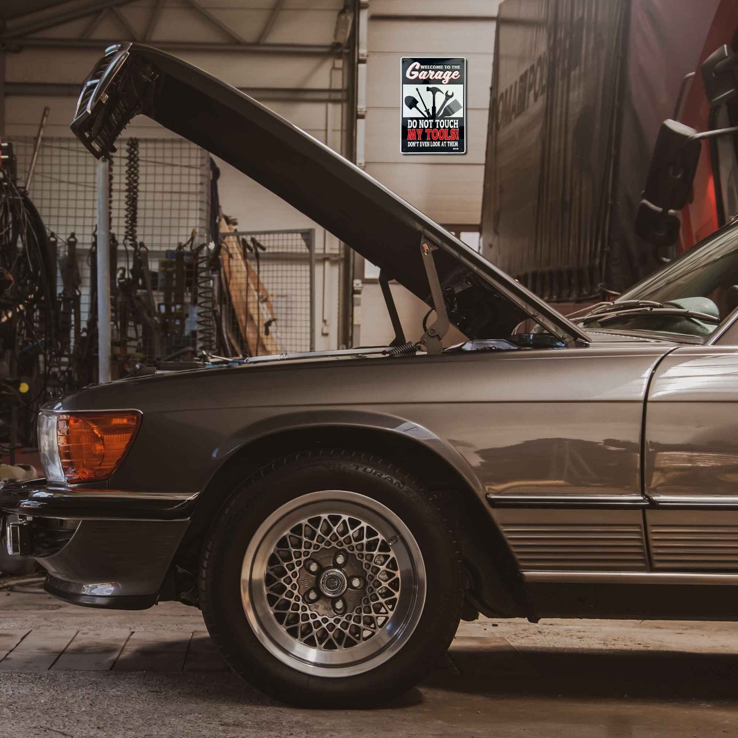 Vintage car with open hood in a garage setting
