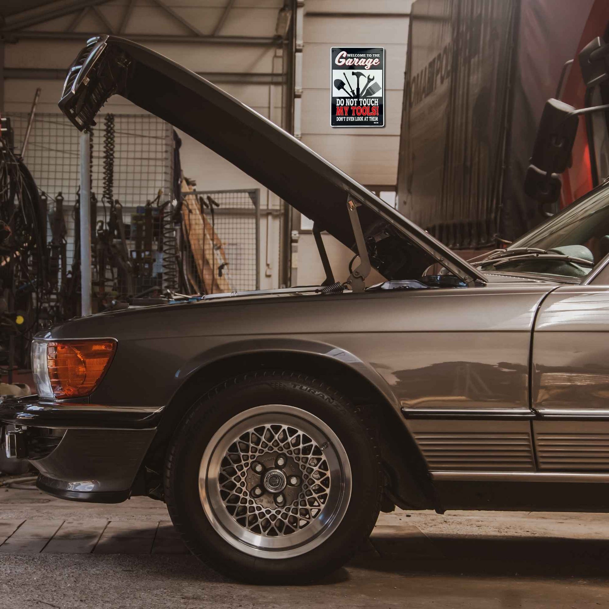Vintage car with open hood in a garage setting