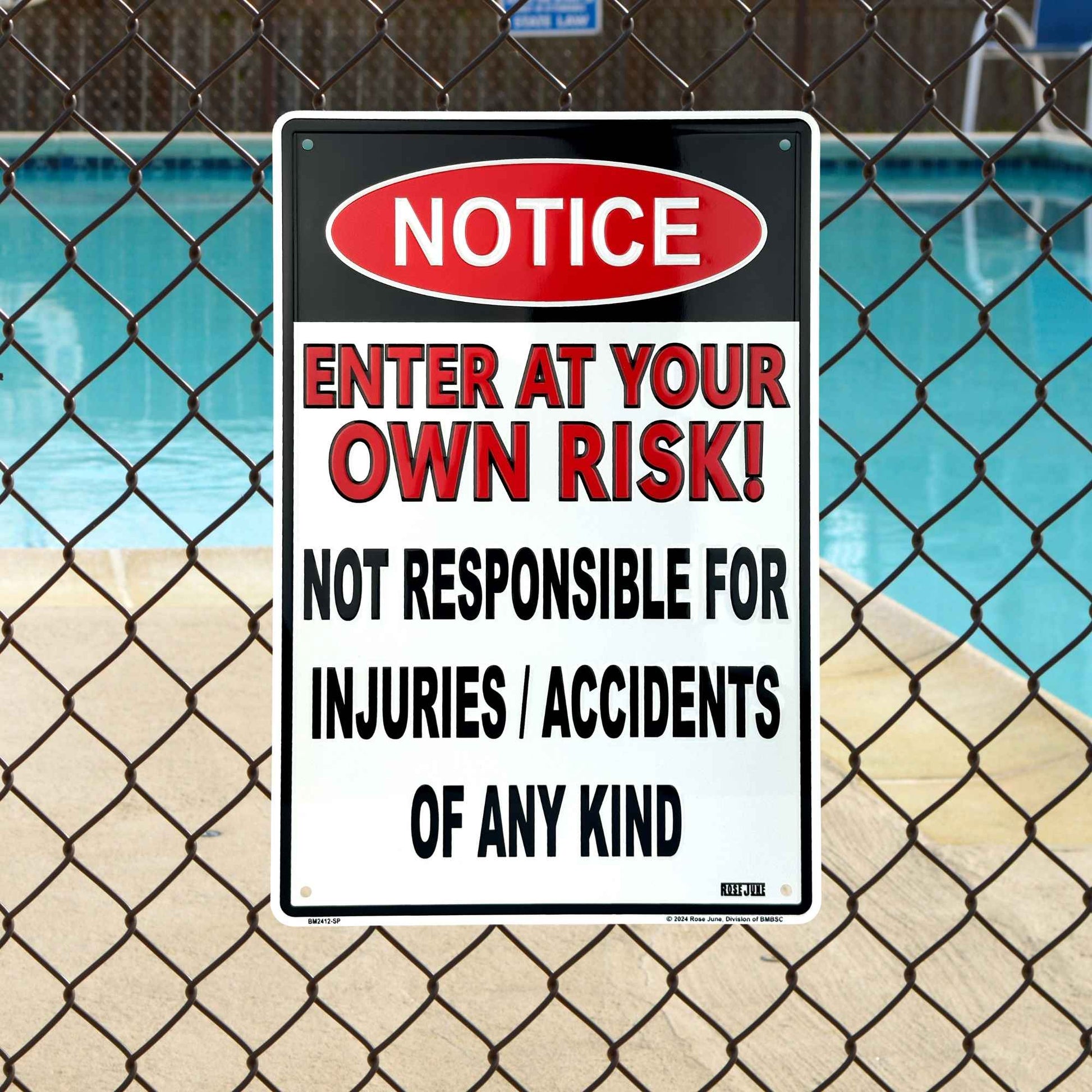Warning sign on a chain-link fence with pool in the background