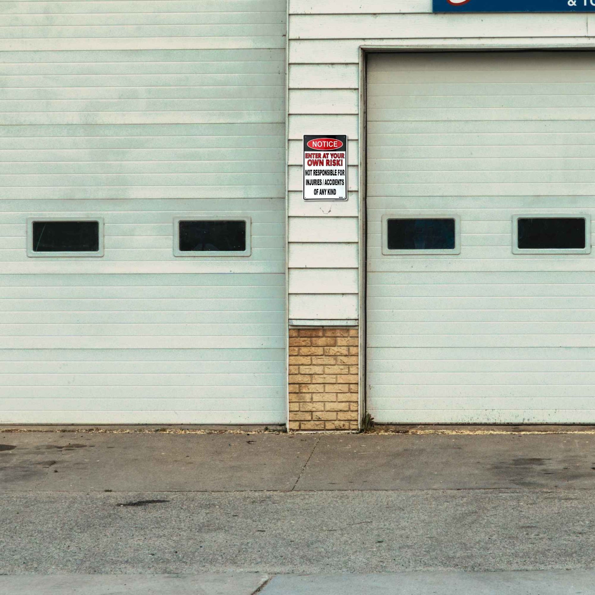 Two industrial garage doors on a building with a small wooden wall between them.
