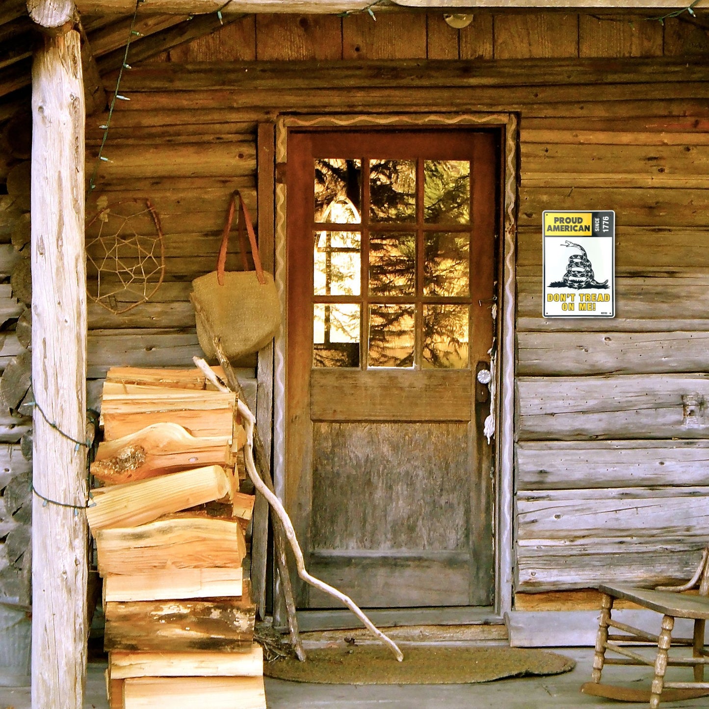 Wooden cabin entrance with logs stacked against the wall and a sign on the door. BM2424-SP