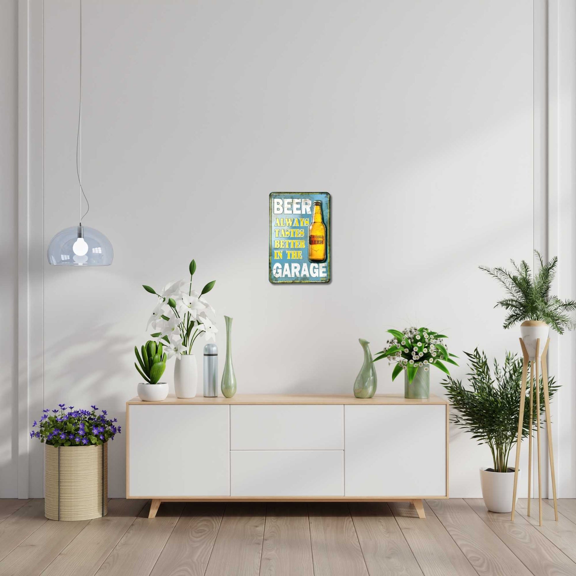 Modern interior with a sideboard, plants, and a decorative sign on a white wall.