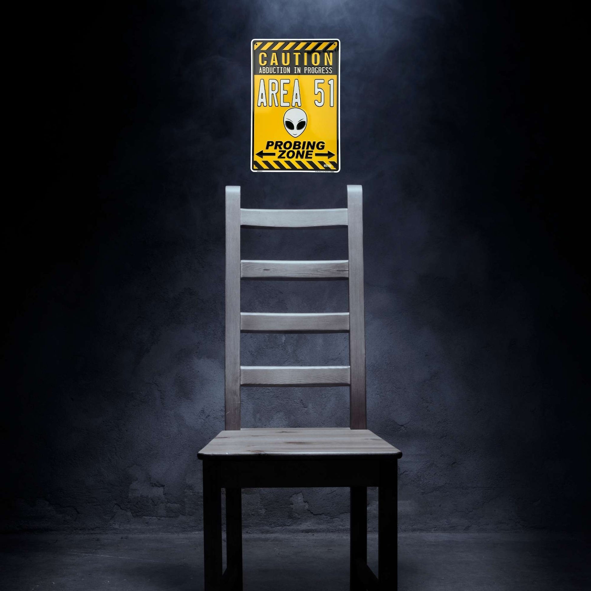 Wooden chair with a 'Caution Area 51' sign on a dark background