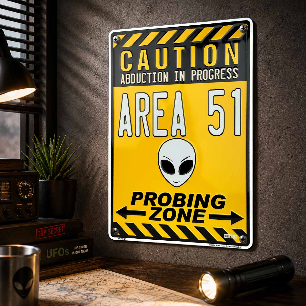 Area 51 abduction sign with alien face on a wall with decor items.