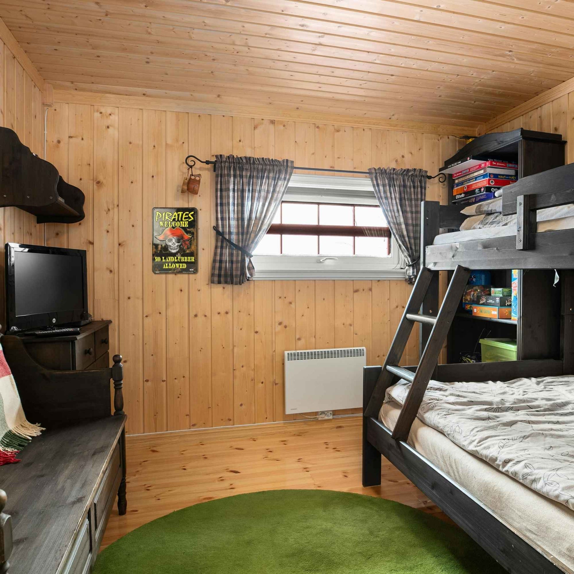 Children's bedroom with bunk beds, TV, and window with curtains.