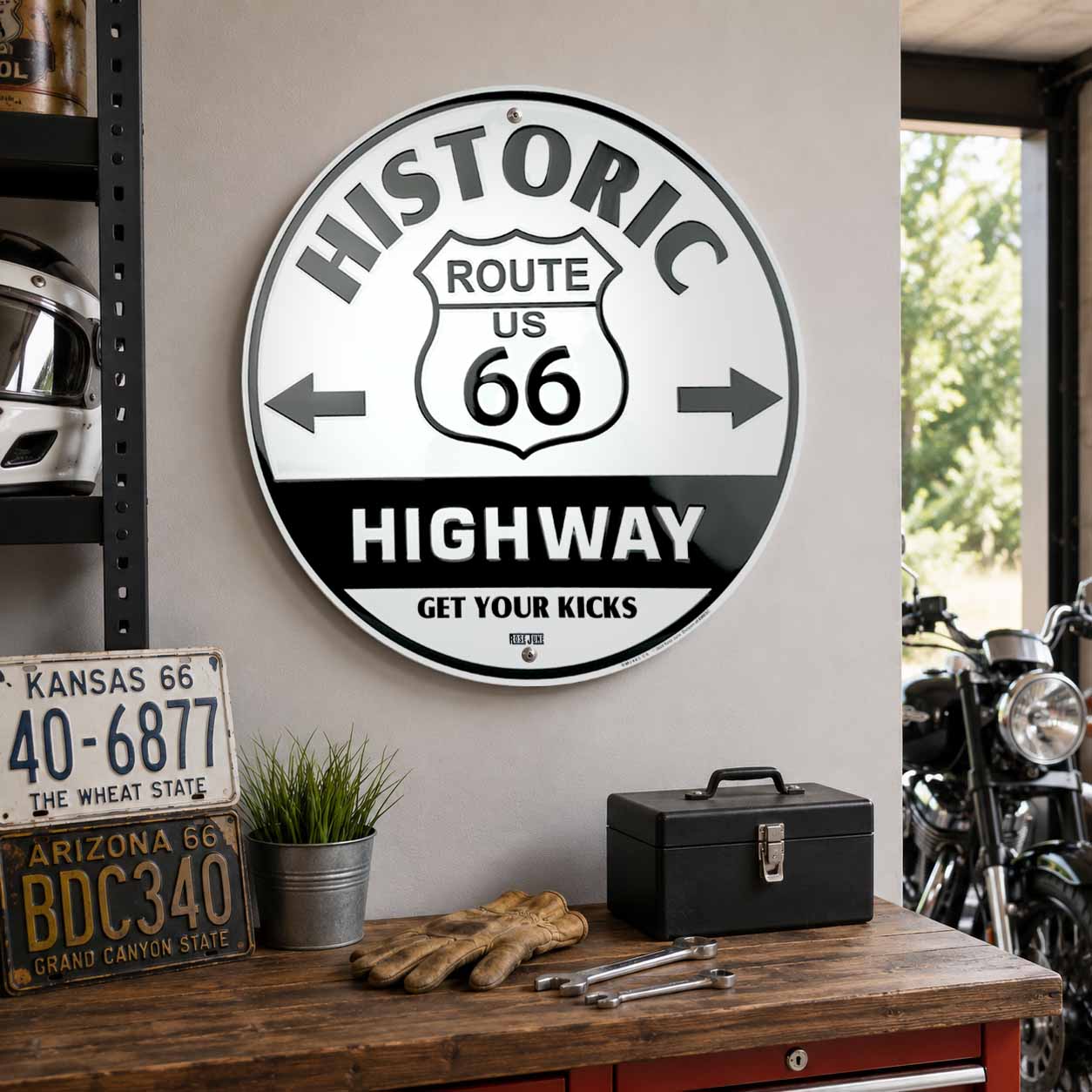 Decorative sign for Historic Route US 66 Highway in a garage setting with tools and a motorcycle.